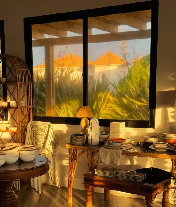 Interior de la tienda bañada por el sol del atardecer con vista al jardín