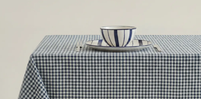 Mesa con mantel a cuadros azul y vajilla artesanal a rayas de BasKula